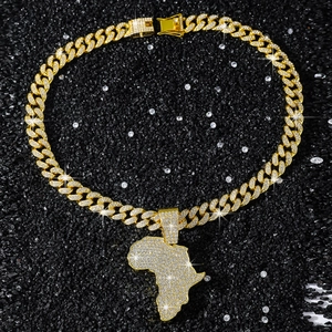 Macro shot of iced out Africa map pendant and golden Cuban link chain on black stones