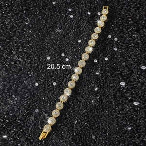 Détail du bracelet tennis doré 10mm avec zircons ronds sur fond de petits cailloux noirs