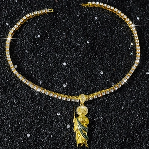Detail of gold Saint Jude pendant with green accents on a cubic zirconia tennis chain