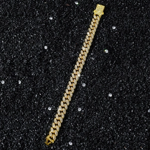 Detail der 10mm goldener Panzerkette mit Kristallen und sicherem Verschluss auf schwarzem Sand