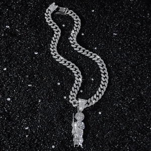 Iced out silver St. Jude pendant with cuban chain necklace on a black stone background