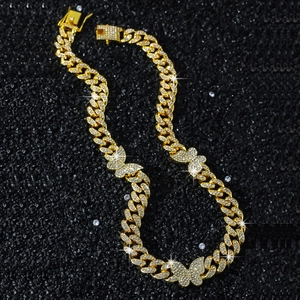 Golden 13mm iced out Cuban chain necklace featuring butterfly pendants on black background