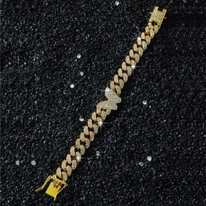 Dettaglio del bracciale cubano hip-hop con ciondolo a farfalla e strass in finitura oro 18K