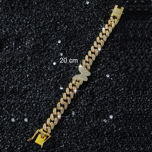 Dettaglio di un bracciale a catena dorata da 20 cm con farfalla su pietra nera