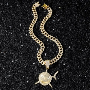 Iced out gold Cuban link chain with a large shark pendant encrusted in white rhinestones