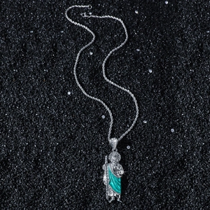 Hip hop St. Jude pendant necklace with green enamel on a black textured background