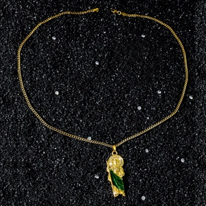 Dettaglio della collana con ciondolo San Giuda in smalto verde e oro su pietre nere