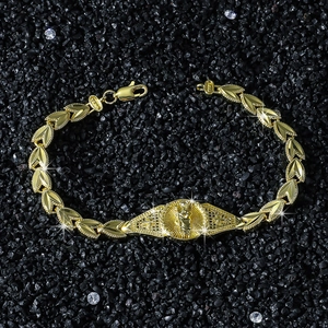 St. Jude religious icon gold plated leaf chain bracelet on black gravel background