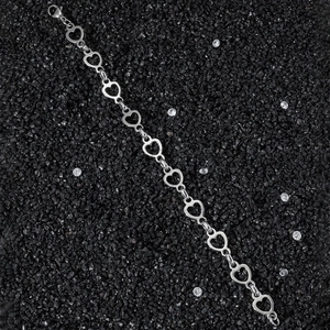 Polished stainless steel heart link chain bracelet for women on a black stone background