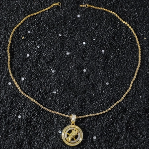 Macro view of Saint Jude spinning pendant with iced-out stones on golden rope chain