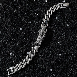 Silver Cuban link bracelet with Saint Jude icon and crystal clasp on black background