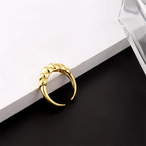 Detailed close-up of a gold croissant twisted ring with a polished metallic finish