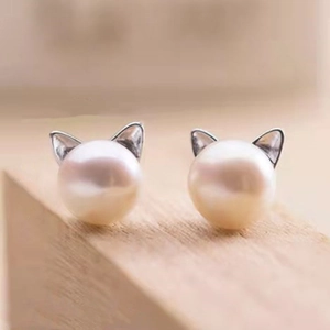Cute S925 sterling silver cat earrings with glossy white freshwater pearls on wood