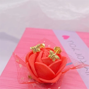 Elegant gold butterfly stud earrings in S925 sterling silver resting on a rose flower