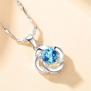 Vue macro d'un pendentif trèfle en argent S925 avec une pierre précieuse bleue
