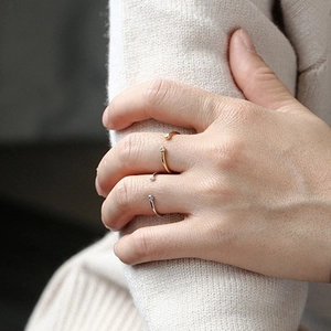 Close-up of minimalist adjustable silver and gold rings with small zircon accents