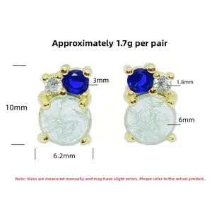 Detail view of gold two-tone stud earrings with light green and blue gemstones