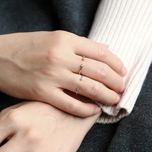 Close-up of minimalist gold and silver S925 sterling silver open rings with small diamonds