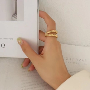 Detailed macro view of S925 sterling silver wavy ring with gold lava texture on hand