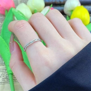 Detailed view of silver braided ring featuring three layered beads on a female hand