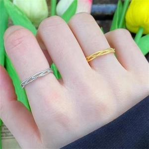 Close-up of twisted rope texture rings in silver and gold colors on a female finger