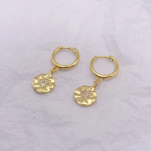 Macro detail of vintage S925 silver gold-plated hoop earrings with starburst charms