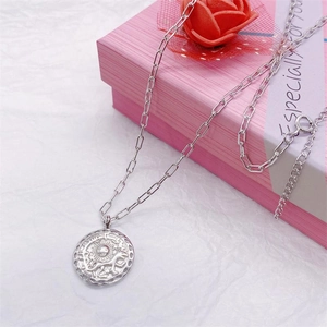 Detail of S925 silver sun pendant necklace draped over a pink gift box display