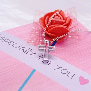 Collier avec pendentif croix évidée en argent S925 sur une boîte cadeau avec rose