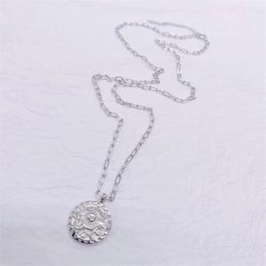 Macro detail of S925 sterling silver sun puppy pendant with paperclip chain link
