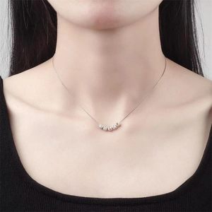 Close-up of S925 sterling silver necklace with seven beads on model neck in black background