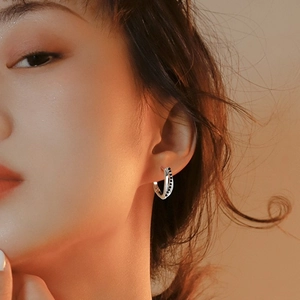 Gros plan sur une boucle d'oreille S925 en argent avec pierres noires sur modèle