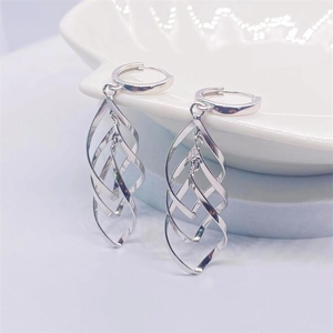 Macro detail of S925 sterling silver long spiral twist drop earrings on a white plate