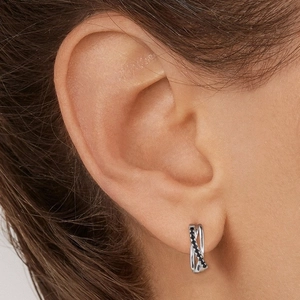 Gros plan de boucles d'oreilles croisées en argent S925 serties de diamants noirs