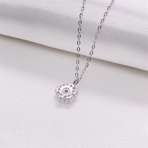 Détail macro du pendentif flocon en argent S925 avec pierre brillante sur soie blanche