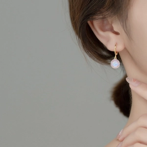 Eleganti orecchini in argento 925 con opale e halo di diamanti indossati da una modella