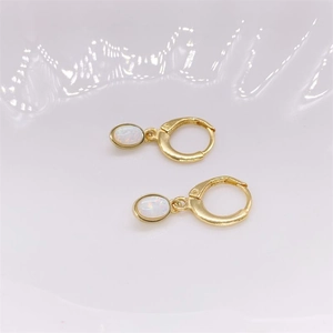 Detail view of gold S925 sterling silver hoop earrings with oval white opal drop pendants