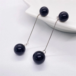 Minimalist S925 sterling silver long drop earrings with black onyx beads on white ceramic