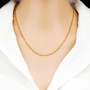 Close-up of golden S925 sterling silver bead chain necklace worn on model's neck