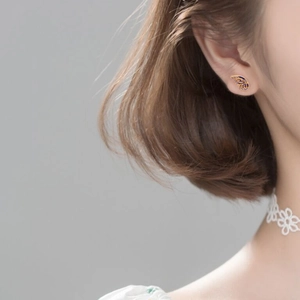 Detailed view of dainty S925 sterling silver butterfly wing stud earrings with blue enamel