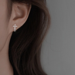 Detailed view of silver cross stud earrings in S925 sterling silver worn by a model
