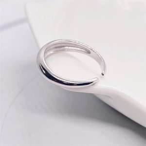 Vista macro laterale dell'anello in argento sterling S925 lucido su porcellana bianca