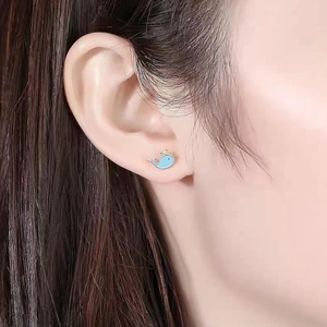 Macro shot of cute S925 silver blue whale stud earring on model's earlobe