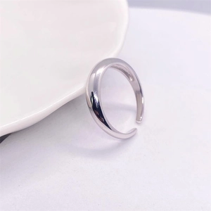 Dettaglio dell'anello aperto minimalista in argento S925 su ceramica bianca