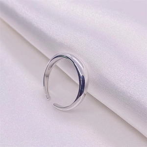 Dettaglio dell'anello in argento S925 lucido su sfondo di seta bianca liscia