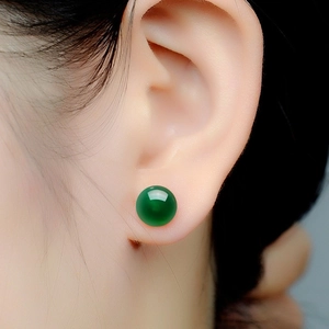 Close-up of green agate stud earring with a polished translucent spherical finish