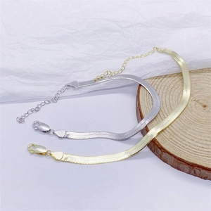 Detailed view of gold and silver herringbone chains with lobster clasp and adjustable link