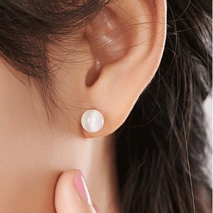 Detailed close-up of S925 silver opal stud earrings showing milky cat-eye effect on ear