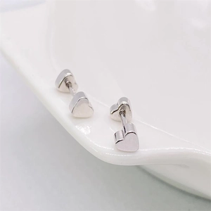 Close-up of minimalist S925 sterling silver heart stud earrings with mirror finish