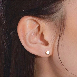 Minimalist S925 silver hexagonal stud earring with 18K gold plating on a female model