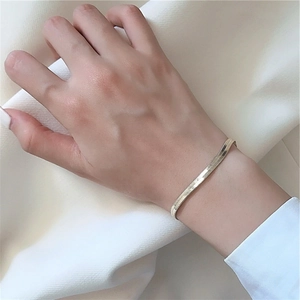 Gros plan d'un bracelet serpent en argent sterling S925 doré porté au poignet d'un mannequin
